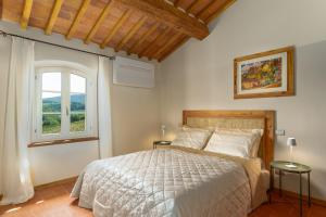 ein Schlafzimmer mit einem großen Bett und einem Fenster in der Unterkunft Il Castro Luxury Apartments in San Gimignano