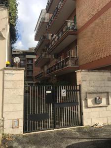 a black gate in front of a building with balconies at La Pinetina Roma in Rome