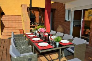 a table with chairs and plates on a patio at Villa Sitges Maria Sunny Oriented SW AC Confortable High Quality 5 star guest coments in Olivella