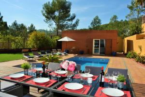 a dining table with wine glasses and flowers on a patio at Villa Sitges Maria Sunny Oriented SW AC Confortable High Quality 5 star guest coments in Olivella