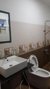 ファンランにあるKhách sạn Ánh Đôngのバスルーム(洗面台、トイレ、鏡付)