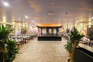 um salão de banquetes com cadeiras e um palco no meio em La Stella Hotel em Ha Long