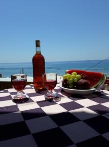 a table with a plate of grapes and a bottle of wine at MARGARITAS' ROOMS in Agios Gordios