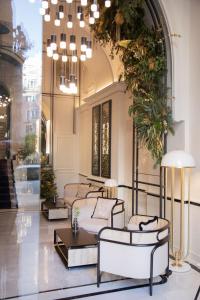 a lobby with four beds and a chandelier at MYR Palacio Vallier in Valencia