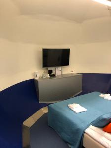 um quarto com uma cama e uma televisão na parede em STF Jumbo Stay Stockholm em Arlanda