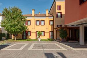 a large yellow building with a tree in front of it at UNAHOTELS Eco Hotel Villa Costanza Venezia in Mestre