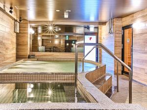 uma piscina num edifício com escadas em Anshin Oyado Premier Nagoya Sakae em Nagoia