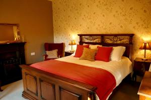 a bedroom with a large bed with red and white pillows at Crookedstone House in Antrim