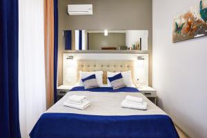 1 dormitorio con 1 cama con 2 toallas en ANTARES Apart hotel, en Leópolis