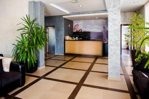 a lobby with a reception desk and potted plants at Hotel Villa Monako in Međugorje