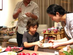 a woman offering a child a plate of food at Zen Tea House Seven Stars Park in Guilin