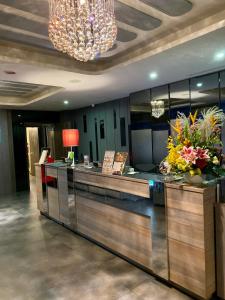 a lobby with a reception counter with flowers and a chandelier at Beauty Hotels Taipei - Hotel B7 in Taipei