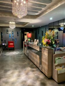 a hotel lobby with a reception desk and a chandelier at Beauty Hotels Taipei - Hotel B7 in Taipei