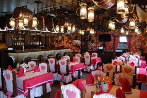 a restaurant with pink tables and chairs and a bar at Готель Баварія in Poltava