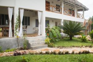 a house with a garden and stairs in front of it at Villa Kiota in Paje