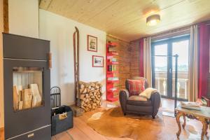 a living room with a chair and a fireplace at Ferienwohnungen Alpentraum - Lieblingsplätzle in Bolsterlang