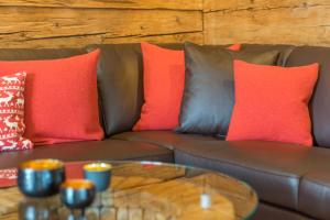brązowa kanapa z czerwonymi poduszkami i stolikiem kawowym w obiekcie Ferienwohnungen Alpentraum - Lieblingsplätzle w mieście Bolsterlang