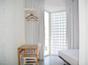 Schlafzimmer mit einem Schreibtisch, einem Bett und einem Fenster in der Unterkunft LoopINN Hostel Cartagena in Cartagena