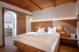 a bedroom with a large bed with a wooden wall at Haus Margreth in Ellmau