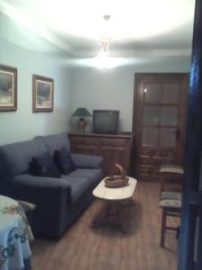 a living room with a blue couch and a table at Los Girones Pacheco in Villanueva de los Infantes