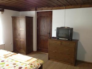 ein Schlafzimmer mit einem Bett und einem TV auf einer Kommode in der Unterkunft Ristevata Guest House in Kovachevitsa