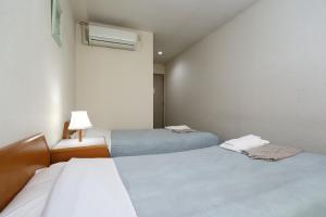 三沢市にあるホテル天水のベッド2台とランプが備わる部屋