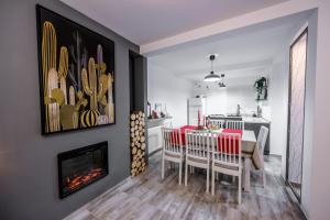 a dining room with a table and chairs and a fireplace at Vila Time Busteni in Buşteni