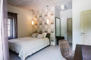 a bedroom with a bed and two chairs in it at Reinis in Turaida