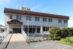 a building with a parking lot in front of it at Hotel Tensui in Misawa