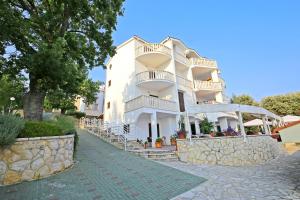 duży biały budynek z kamienną ścianą w obiekcie Depadansa Hotel Lucija*** w mieście Posedarje +20 zdjęć