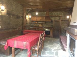 a dining room with a table and a kitchen at Ristevata Guest House in Kovačevica