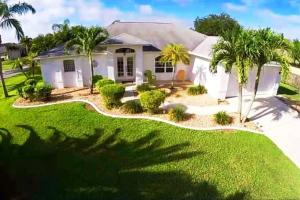 a house with palm trees in front of it at VILLA PALM ISLAND in Cape Coral