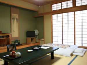 a bedroom with a bed and a table with a coffee table at Kashiwaya in Chikuma