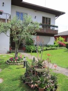 un jardín frente a una casa con un árbol y flores en B&B Ponte Marchese, en Caldogno