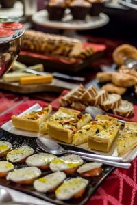 une table avec une assiette de nourriture avec du pain et des cuillères dans l'établissement Arosfa Hotel London by Compass Hospitality, à Londres