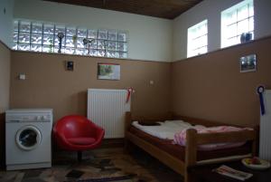 a bedroom with a bed and a washing machine at Dabasi Lovas Vendégház in Dabas