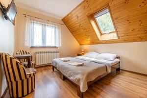 a bedroom with a bed and a window and a chair at Noclegi u Kiesza in Ustrzyki Dolne