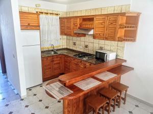 a kitchen with wooden cabinets and a counter top at VV Dúplex Los Cancajos "by henrypole home" in Los Cancajos