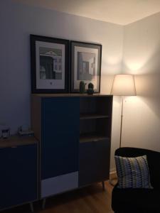 a living room with a blue dresser and a lamp at PETIT STUDIO SYMPA EN CENTRE VILLE in Le Touquet-Paris-Plage