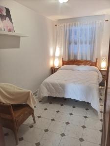 een slaapkamer met een bed, een raam en een stoel bij VV Dúplex Los Cancajos "by henrypole home" in Los Cancajos