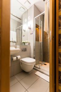 La salle de bains est pourvue de toilettes, d'un lavabo et d'une douche. dans l'établissement Arosfa Hotel London by Compass Hospitality, à Londres