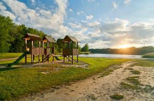 a park with a playground next to a body of water at KNAUS Campingpark Oyten in Oyten