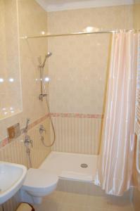 a bathroom with a shower and a toilet and a sink at Готель Баварія in Poltava +8 photos