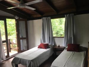 sypialnia z 2 łóżkami i oknem w obiekcie Cabañas Das Dorf w mieście Costa del Este