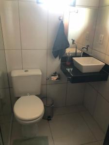 a bathroom with a white toilet and a sink at Casa temporada centro capitolio MG in Capitólio +11 photos