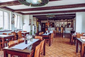 a restaurant with tables and chairs and a bar at Przystań Łeba Resort&Restaurant in Łeba