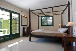 a bedroom with a four poster bed and large windows at La Cumbre in Jávea