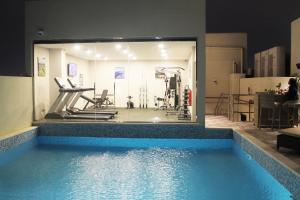 een kamer met een zwembad en een fitnessruimte bij Saraya Palace Hotel in Doha