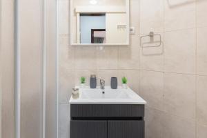 a bathroom with a sink and a mirror at Deluxe Bright Flat with Netflix by Host Wise in Porto