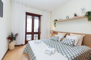 a bedroom with a bed with towels on it at Deluxe Bright Flat with Netflix by Host Wise in Porto